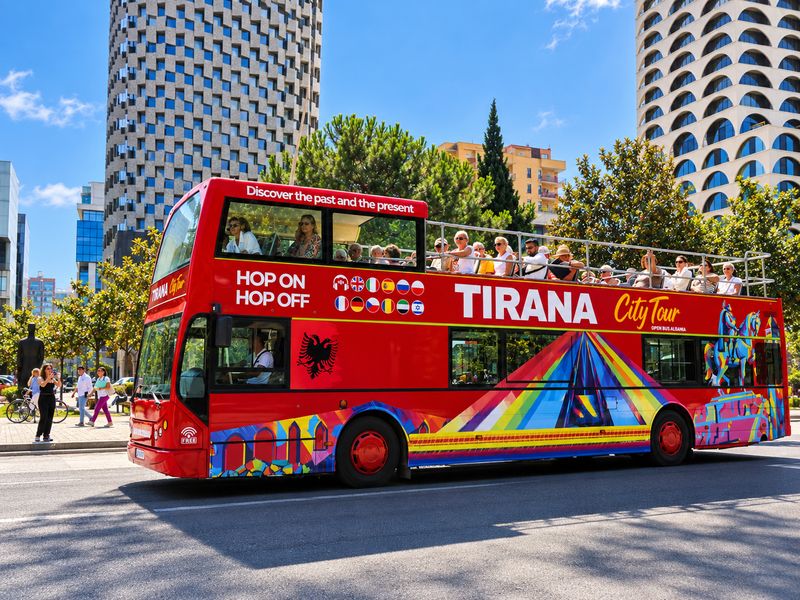 HOBUS hop-on hop-off double-decker bus with passengers on the open top deck in Tirana, Albania